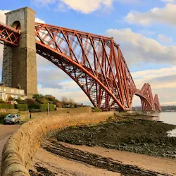 The iconic Forth Bridge spanning the Firth of Forth, showcasing its distinctive red iron structure.