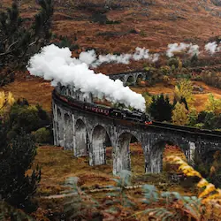 The Glenfinnan Viaduct, a striking railway viaduct arching gracefully over lush Scottish landscapes.
