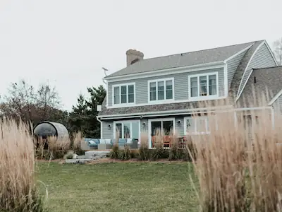 A large cottage surrounded by a vibrant garden, featuring modern accents that enhance its charm.