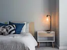 A bright and airy bedroom featuring minimalist furniture, creating a serene and uncluttered space.