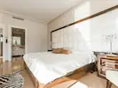 A luxurious bedroom featuring a large bed with a prominent white upholstered headboard, exuding elegance and comfort.