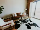 A cosy and inviting living room with a large cow rug as the focal point, creating a warm and welcoming atmosphere.