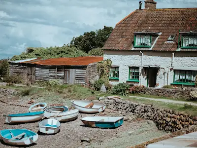Fisherman's Rest, a charming white stone cottage perched right next to the harbour, offering picturesque views and coastal charm.