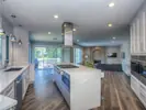 An enormous kitchen showcasing a spacious island and a double oven, designed for both functionality and style.