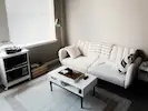 A clean and comfortable living room, featuring a cosy seating arrangement and a welcoming atmosphere.