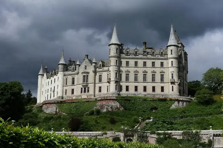 The majestic Dunrobin Castle with its stately towers and landscaped gardens, set against the scenic Highlands backdrop.