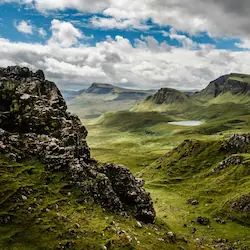 The dramatic moorland of the Quiraing, featuring rugged cliffs and sweeping vistas of rolling hills.
